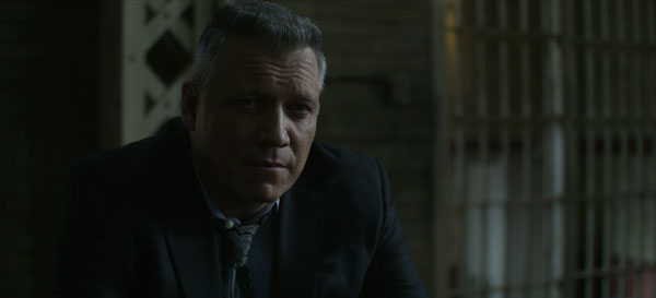 Bill Tench iluminado en penumbra en Mindhunter