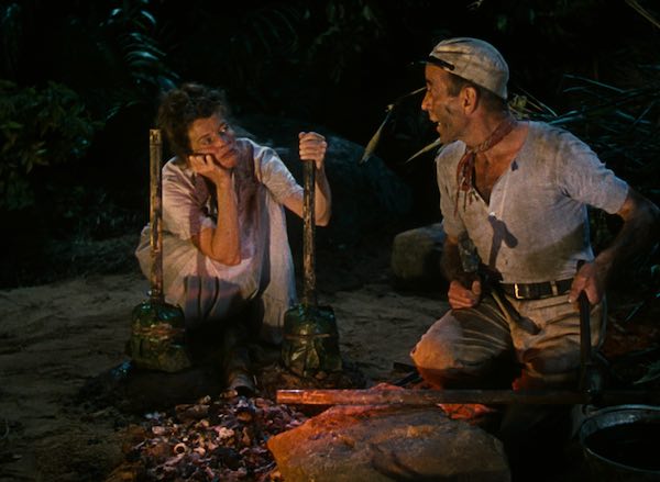 Katharine Hepburn y Humphrey Bogart iluminados junto al fuego