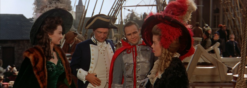 Trevor Howard y Marlon Brando en el puerto en Mutiny on the Bounty con vestuario de época y fotografía en Ultra Panavision 70 de Robert Surtees