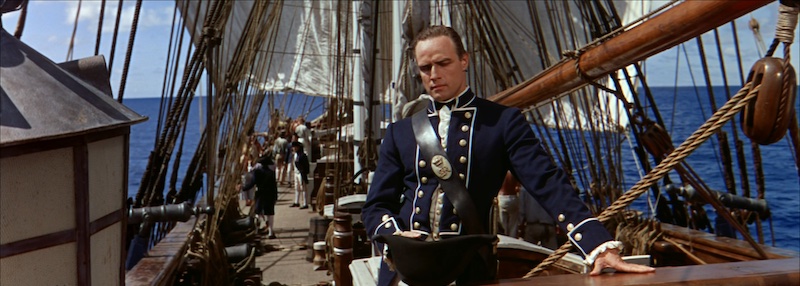 Marlon Brando en la cubierta del barco en Mutiny on the Bounty con el mar al fondo y fotografía panorámica de Robert Surtees