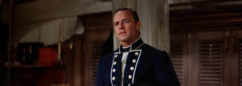 Marlon Brando en un interior del barco en Mutiny on the Bounty con luz dura clásica y uniforme naval