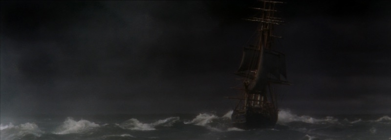 Barco en mitad de una tormenta nocturna en Mutiny on the Bounty con oleaje y atmósfera oscura fotografiada por Robert Surtees