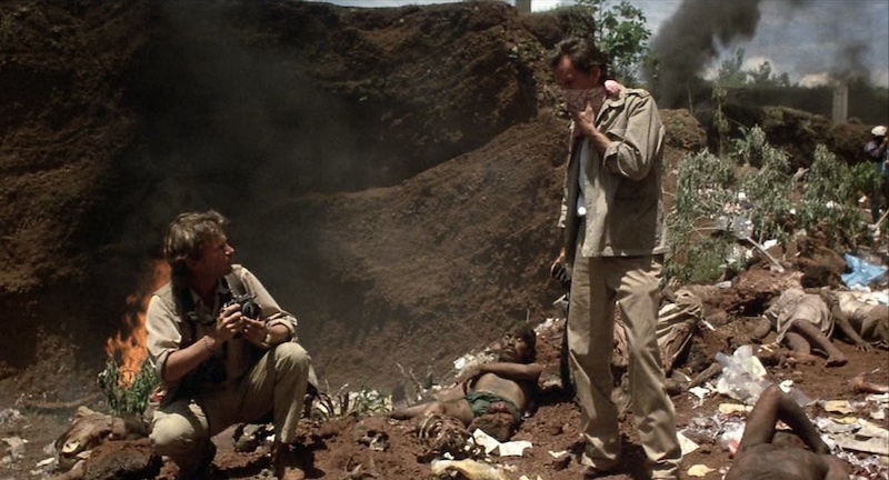 James Woods y John Savage entre cadáveres en Salvador, escena rodada por Robert Richardson con luz dura y realismo bélico