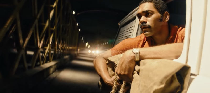 O Agente Secreto 2025 personaje en coche durante escena nocturna con altas luces cálidas y fotografía anamórfica Panavision