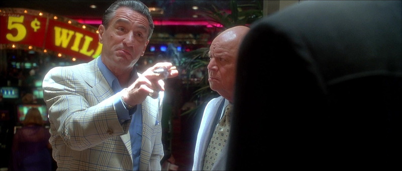 Robert De Niro como Sam Rothstein señala en el casino bajo luces cenitales en Casino (1995)