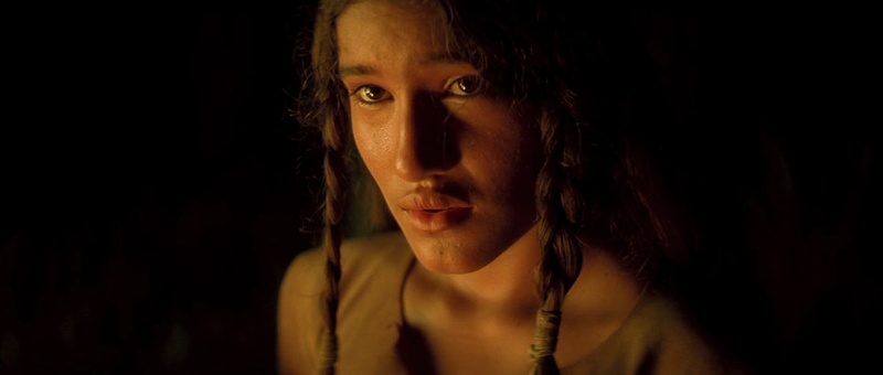Primer plano femenino iluminado por fuego en The New World, fotografía de Emmanuel Lubezki