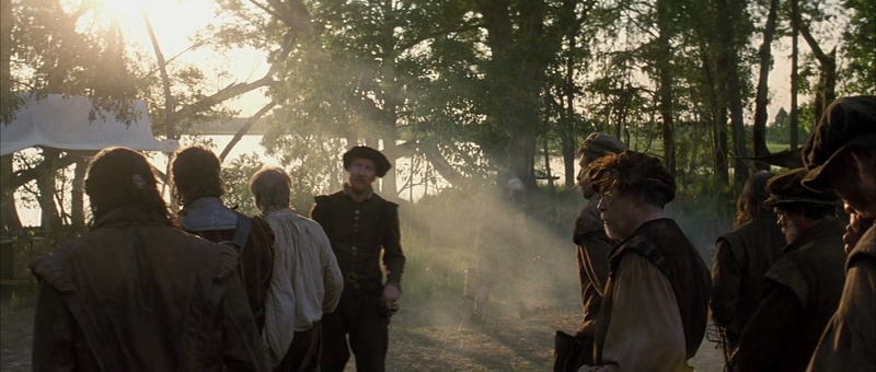 Colonos reunidos a contraluz en The New World, fotografía naturalista de Emmanuel Lubezki
